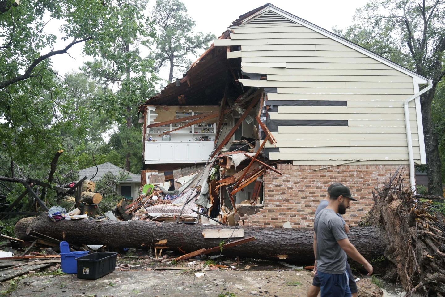 People gather outside a home in the 17400 block of Rustic Canyon Trail where Maria Loredo, 74, died after a tree fell on her second story bedroom during Hurricane Beryl Monday, 8 July 2024, in Houston. Photo: Melissa Phillip / Houston Chronicle / AP