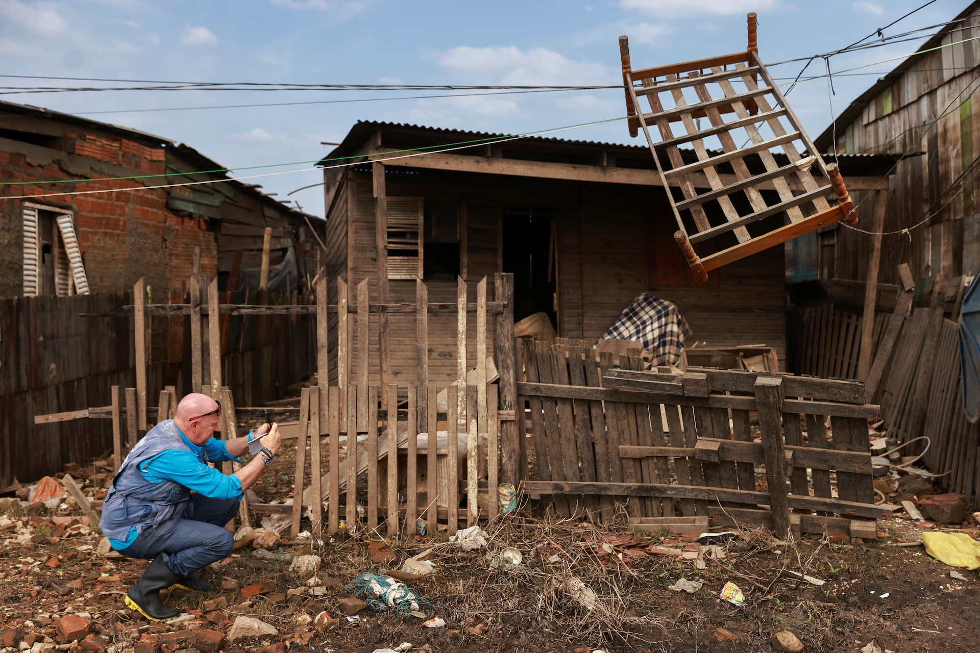 Andrew Harper, climate advisor for the UN refugee agency (UNHCR), photographs a house partially destroyed by the floods that hit Porto Alegre, in the state of Rio Grande do Sul, Brazil, 23 June 2024. Photo: Diego Vara / REUTERS