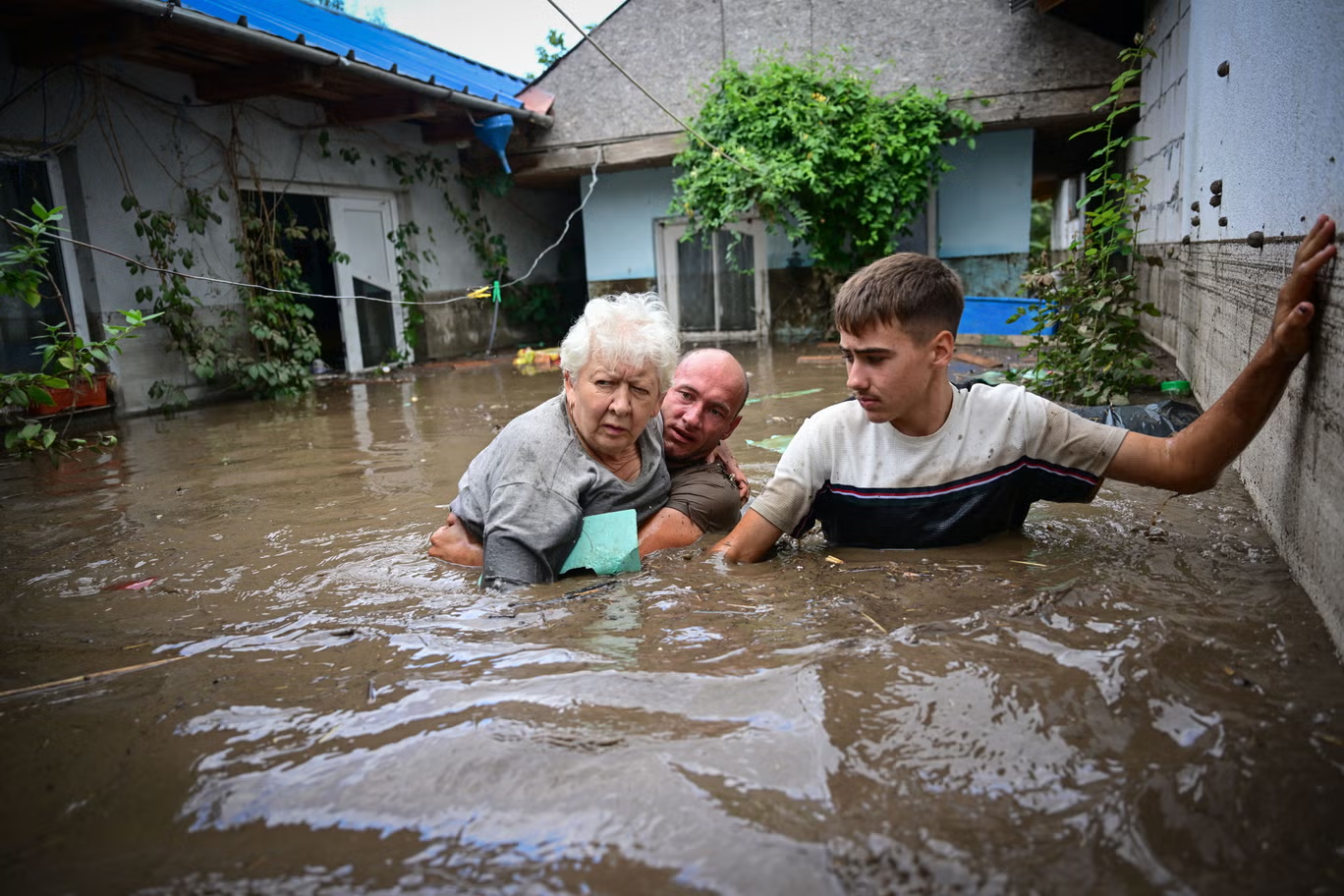 Local residents rescue an elderly person from the rising flood waters in the Romanian village of Slobozia Conachi, 16 September 2024. Photo: AFP / Getty Images