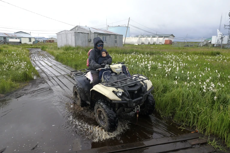 A resident drives along a flooded boardwalk on Wednesday, 14 August 2024. Photo: Rick Bowmer / AP