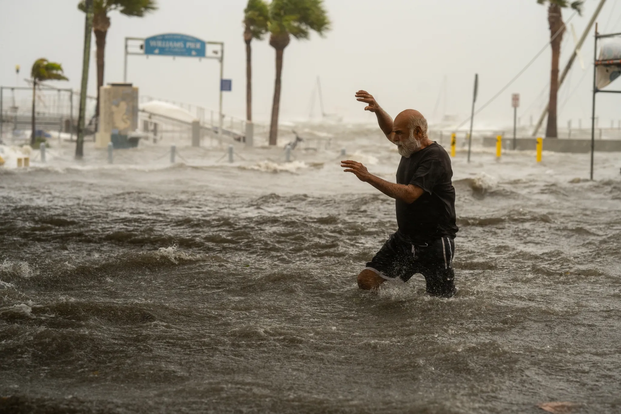 A man crosses a storm surge flooded area on the coast of Gulfport, Florida, as Hurricane Helene passed through the Gulf of Mexico to the West on Thursday, 26 September 2024. Photo: Thomas Simonetti / The Washington Post / Getty Images