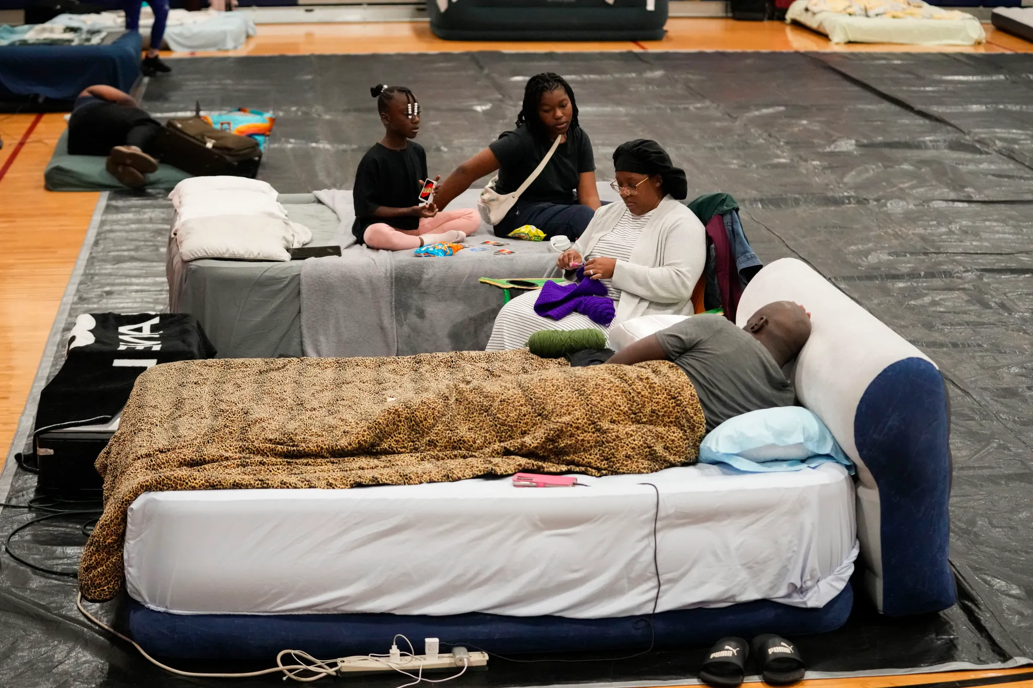 Sharonda and Victor Davis, of Tallahassee, sit with their children Victoria background left, and Amaya, background right, inside a hurricane evacuation shelter at Fairview Middle School, ahead of Hurricane Helene in Leon County, Florida, on Thursday, 26 September 2024. Photo: Gerald Herbert / AP Photo